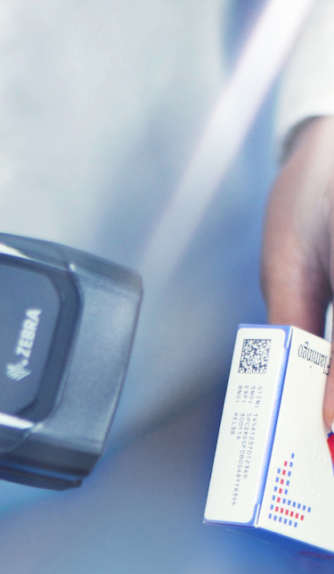 A portrait shot close up of a carton with serialisation being scanned